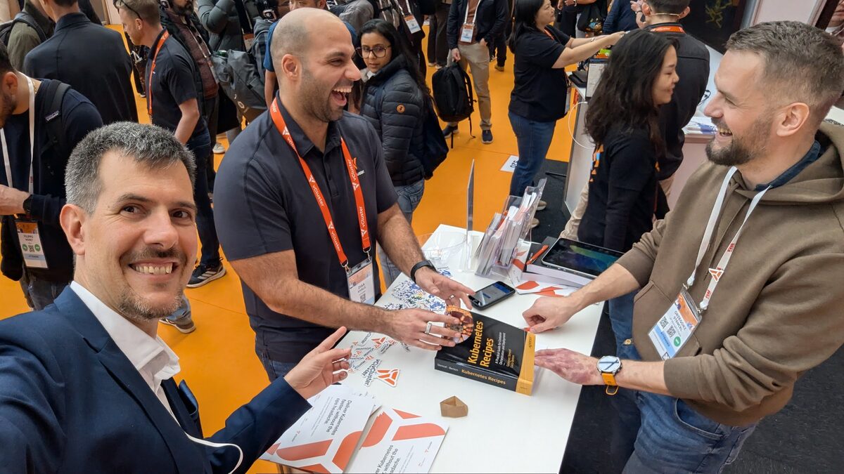 Luca Berton signing Kubernetes Recipes books at KubeCon EU 2026 booth
